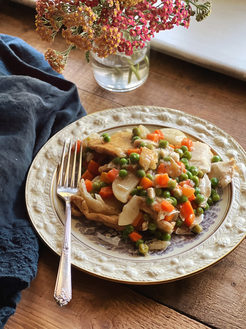 chicken pot pie served on an antique plate with an embossed rim