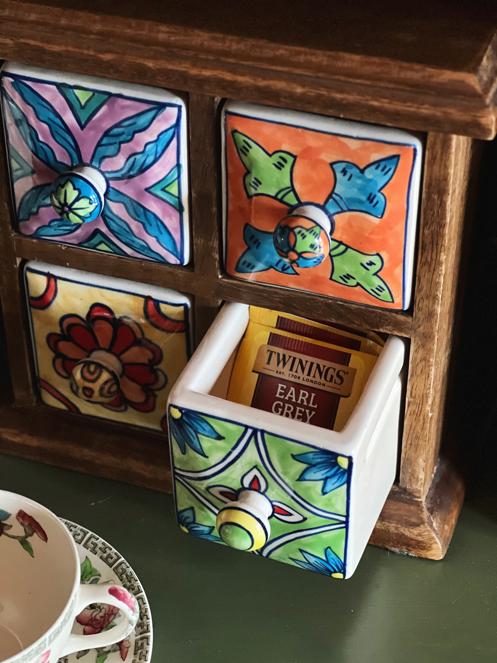 Small vintage wood cabinet with ceramic drawers open for tea and trinket storage