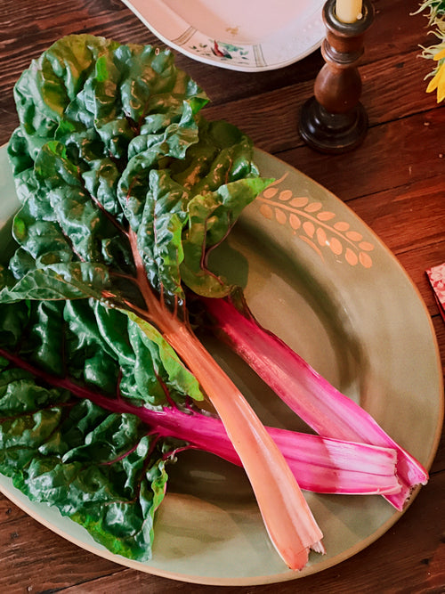 Swiss chard on a decorative Pottery Barn Sausalito platter with a wooden table background