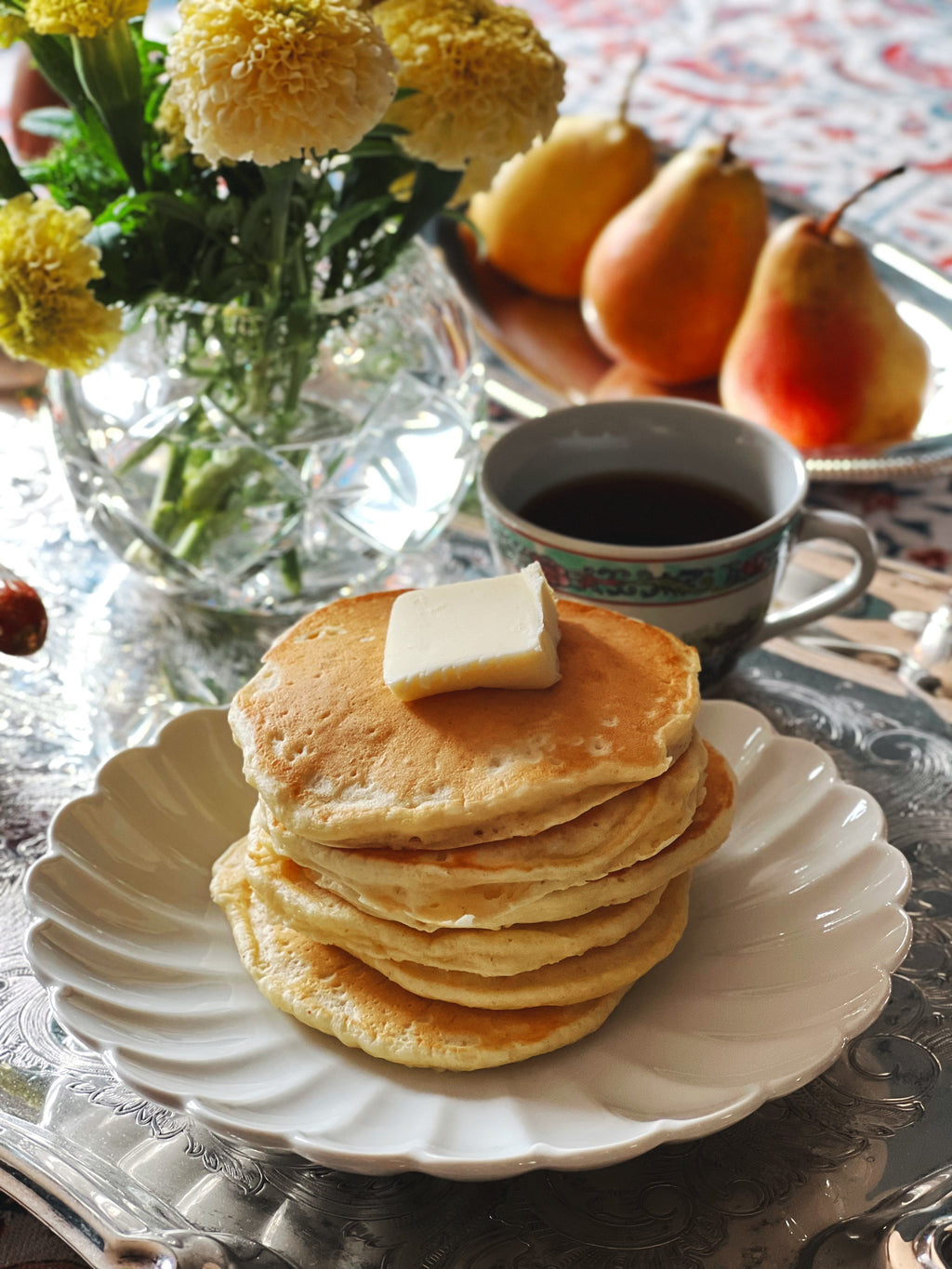 Neiman Marcus white scalloped plate styled with pancakes and coffee
