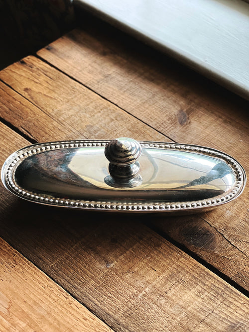 Vintage silverplate oval covered dish with beaded edge on rustic wood table
