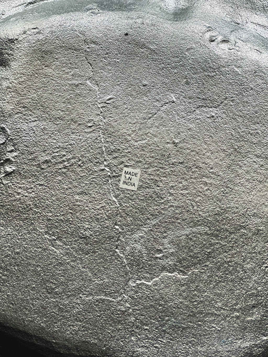 Close-up of a textured silver surface with 'Made in India' label