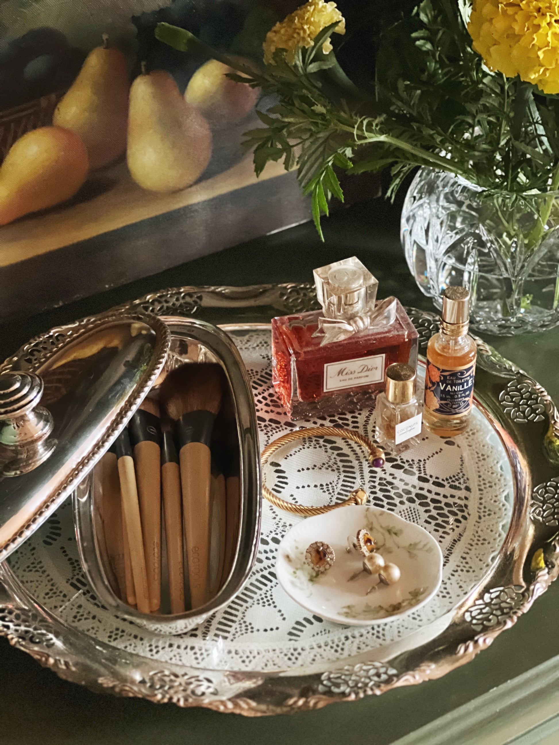 Vintage silver tray styled with perfume and jewelry and make up brushes