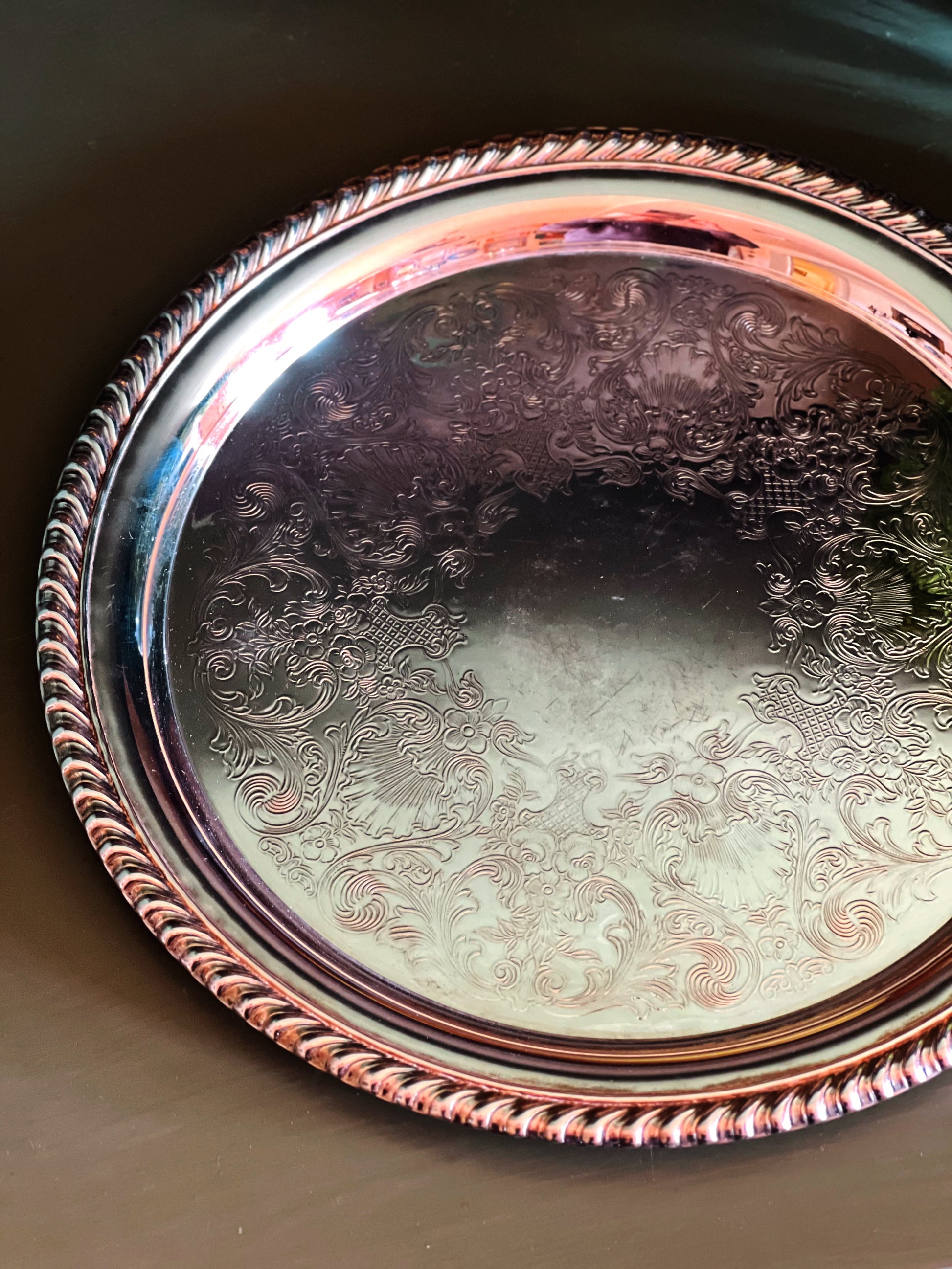 overhead view of a Wm Rogers 870 silver tray with intricate patterns on a dark background