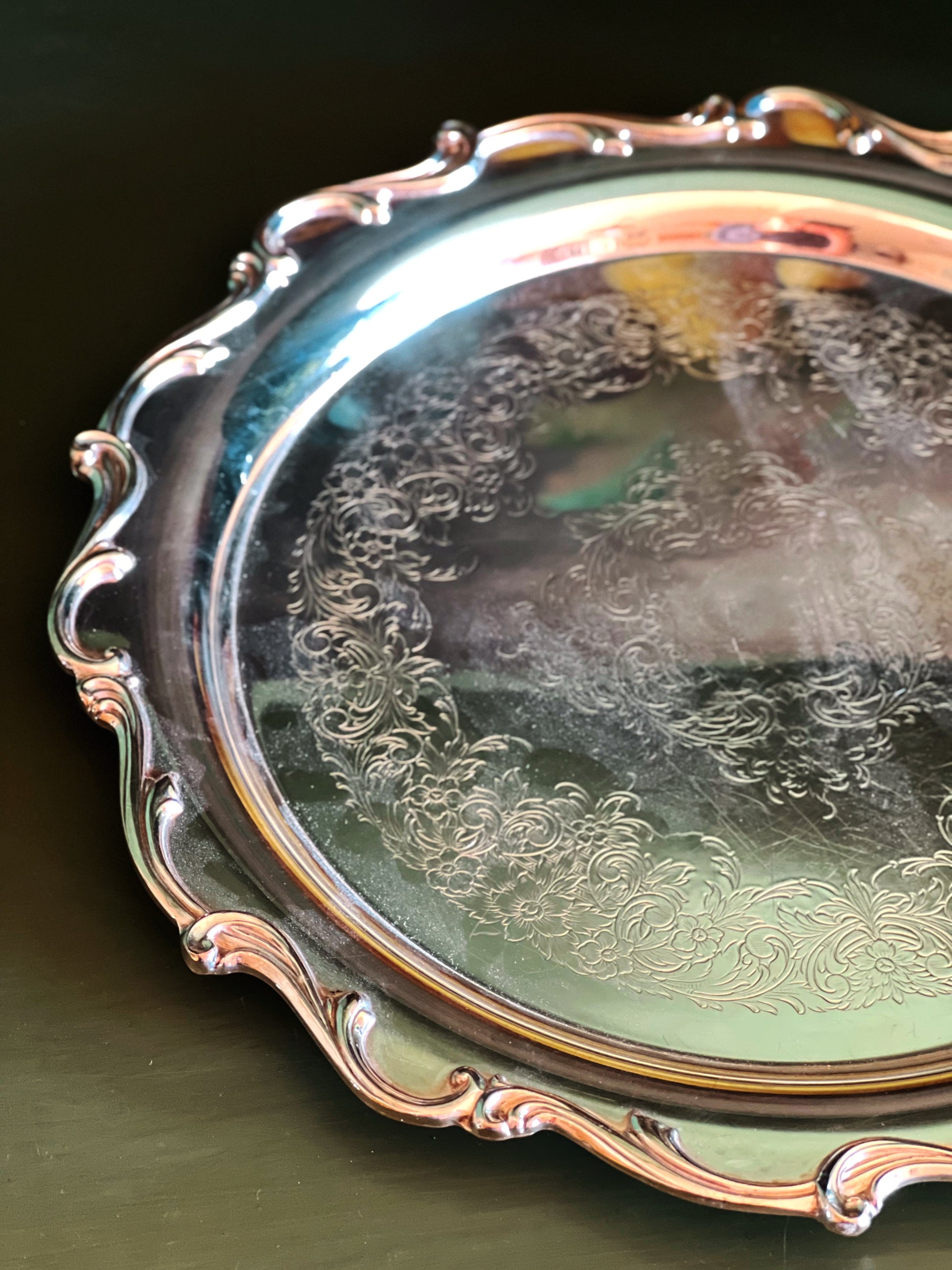 Close-up of an ornate silver tray with detailed patterns on a dark background