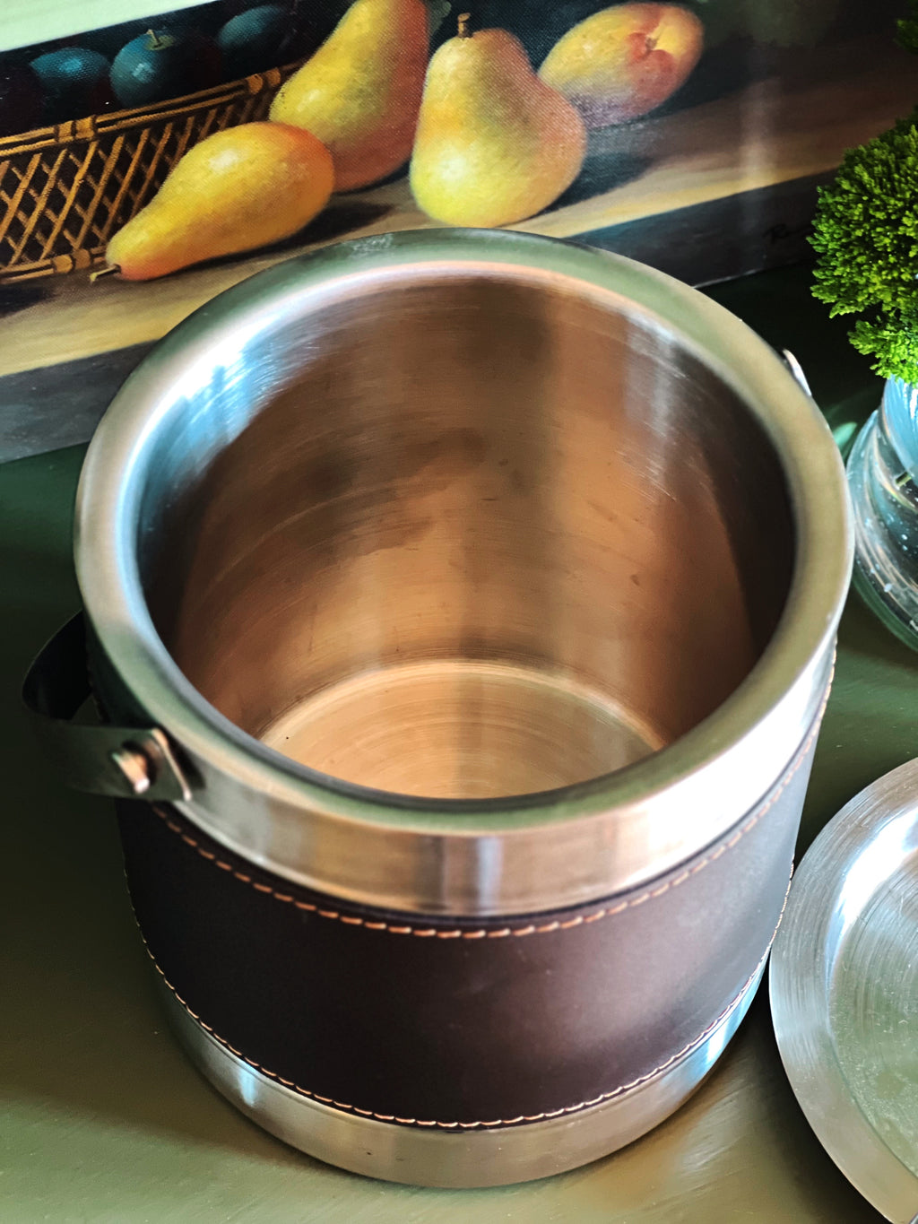 Interior of a vintage silver ice bucket with stitched faux leather wrap and bale handle 