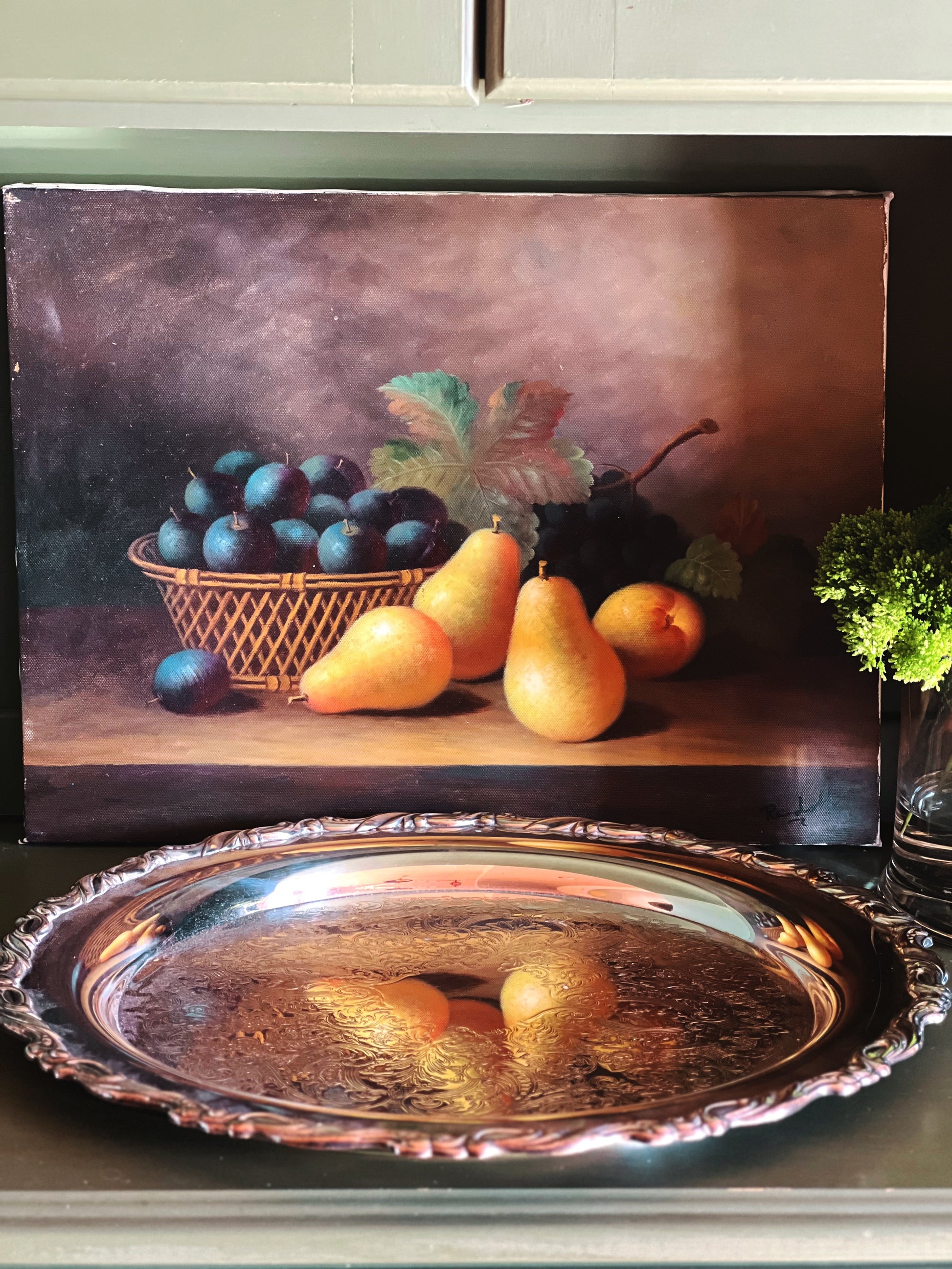 Front view of a vintage silver serving tray on a wood shelf