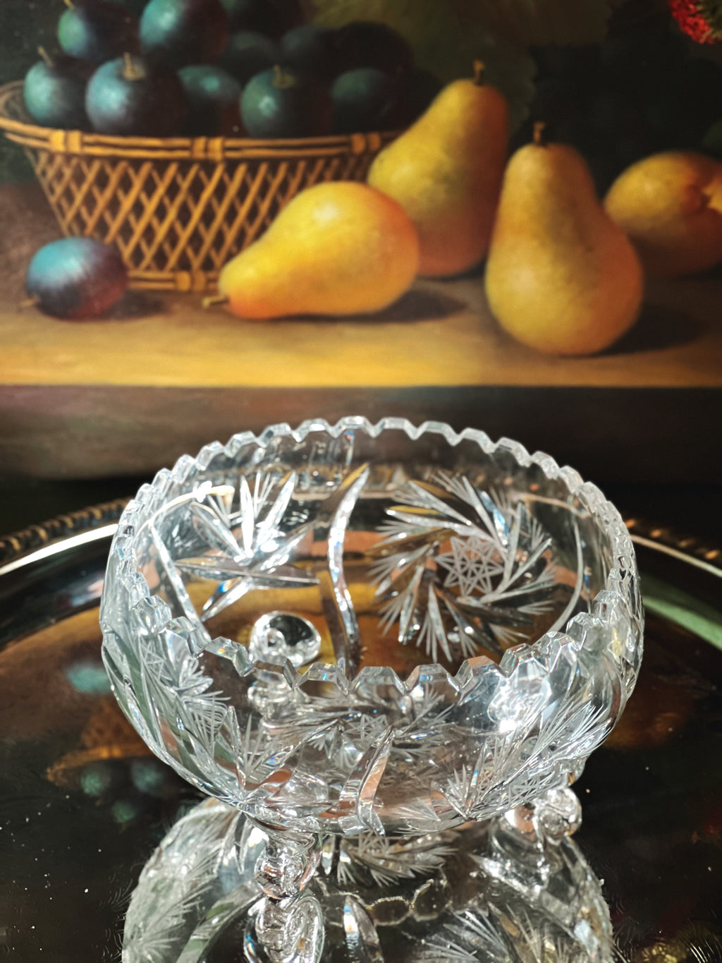 Decorative crystal bowl with fruit in the background