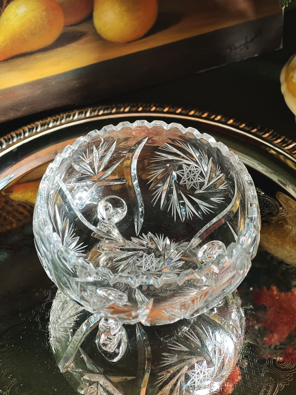 Decorative glass bowl with intricate designs on a reflective surface