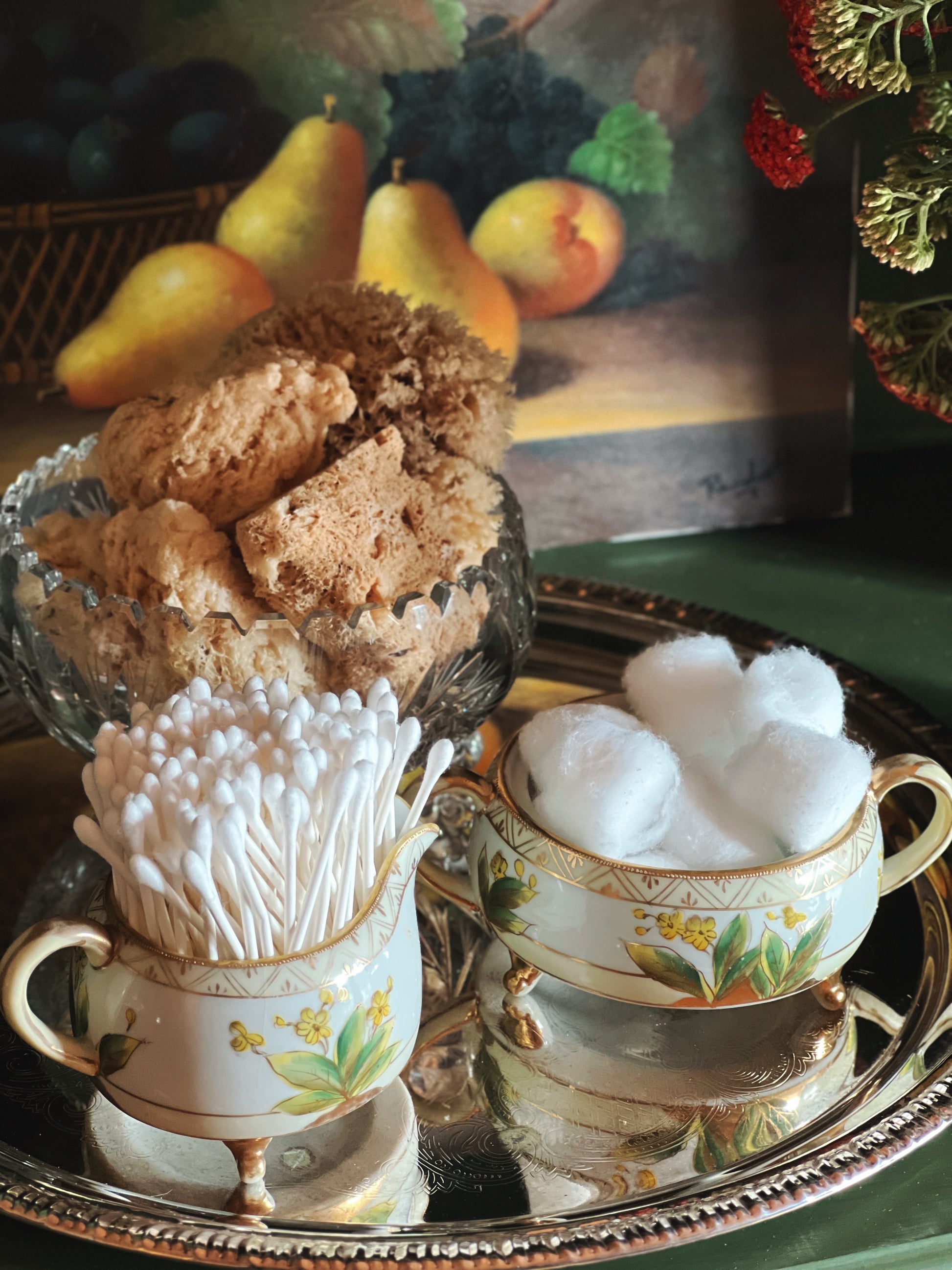 Antique hand-painted Nippon creamer and sugar bowl with yellow floral details styled with cotton balls and makeup brushes on a silver tray
