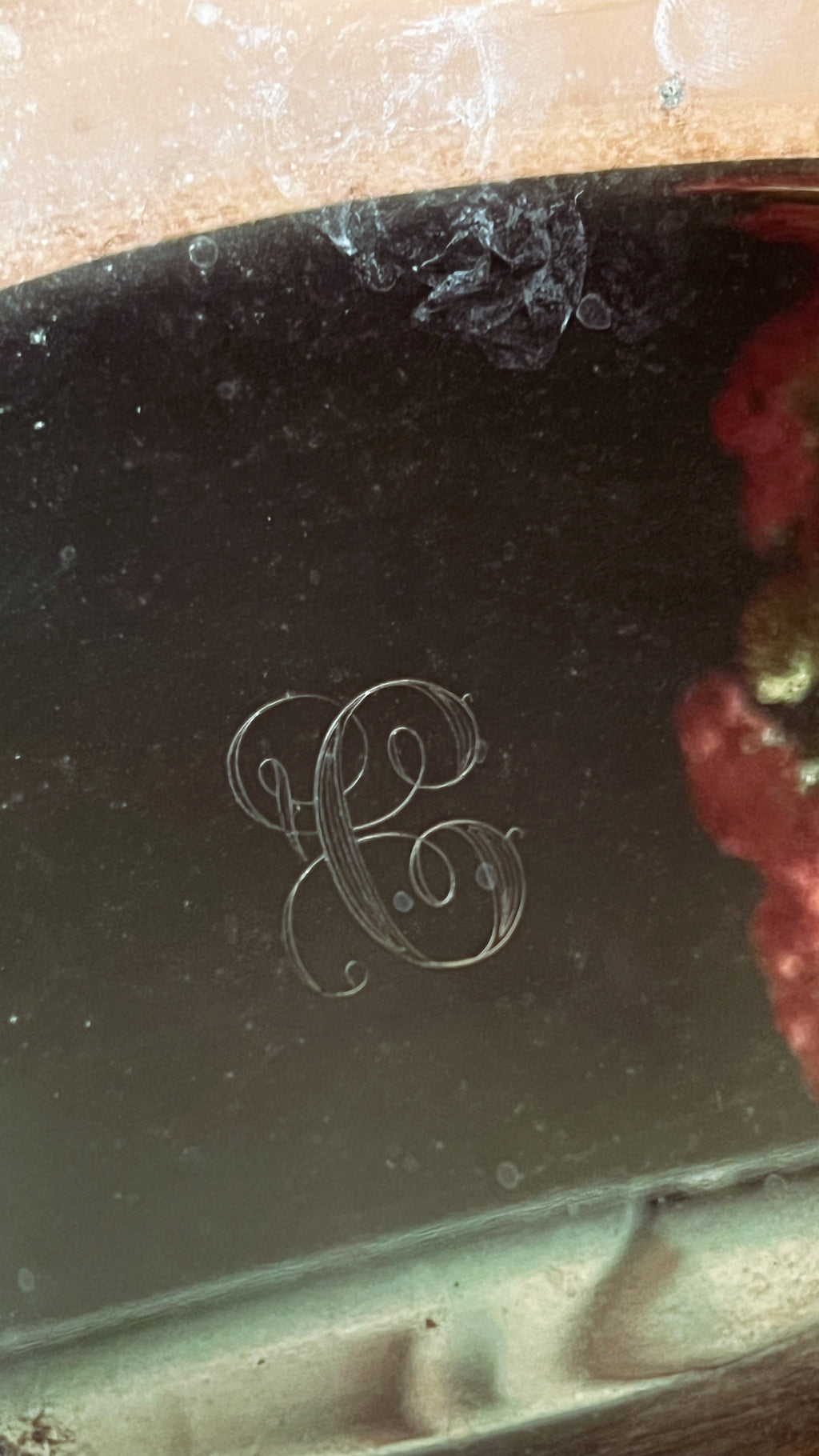 Close-up of a decorative item with an engraved letter 'C' on a reflective surface.