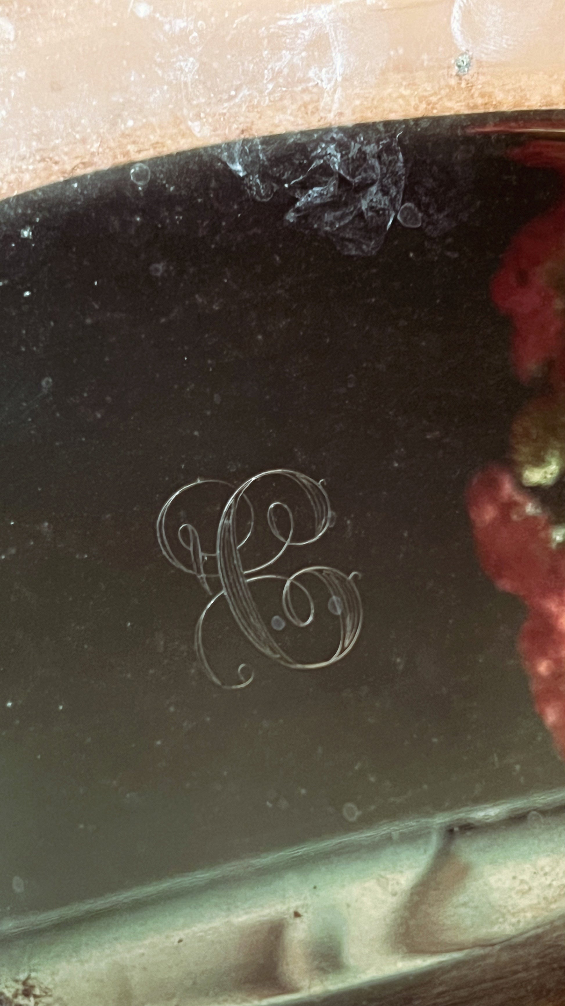Close-up of a decorative item with an engraved letter 'C' on a reflective surface.