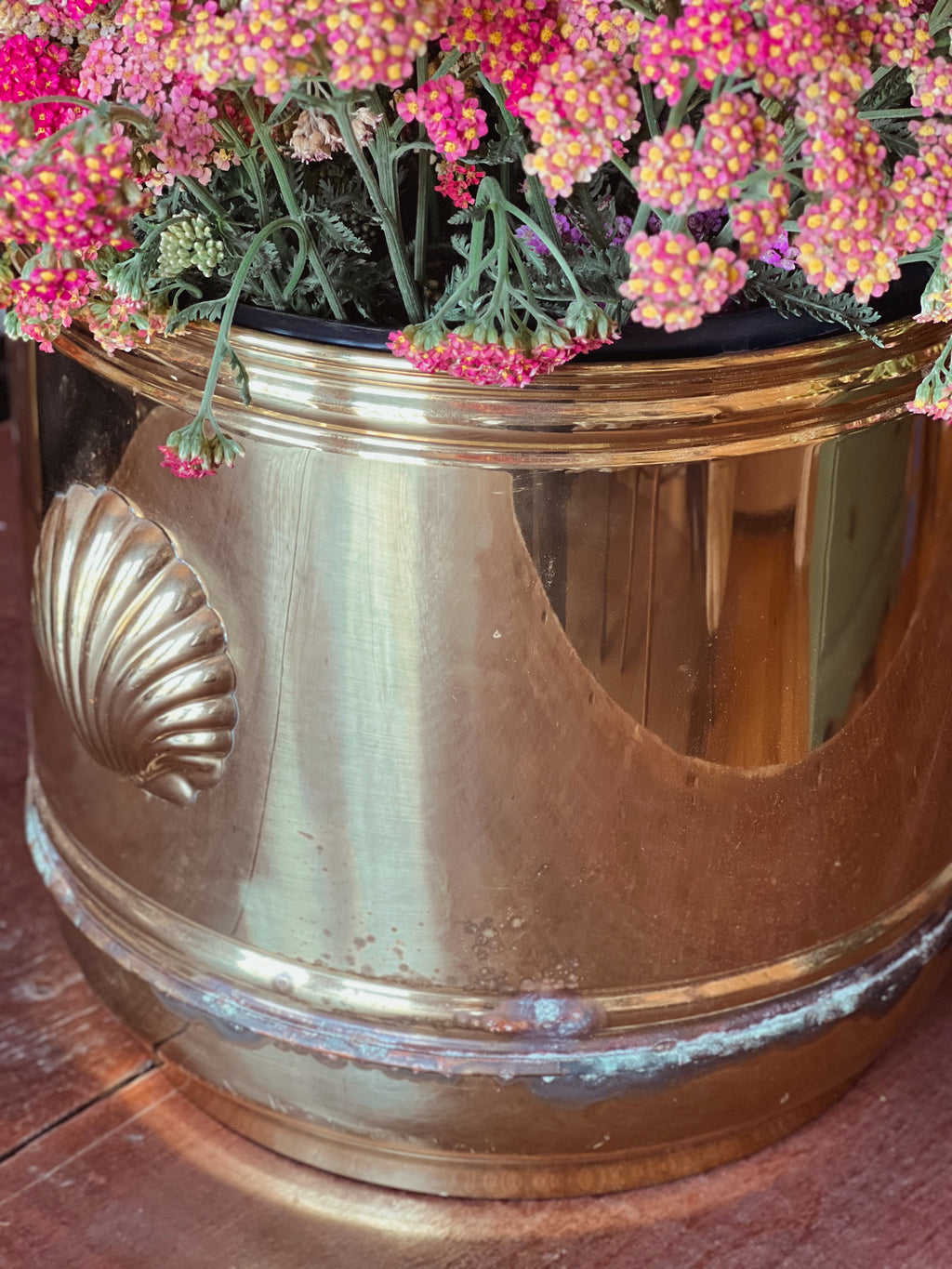 Large vintage English cachepot with shell handles filled with pink flowers.
