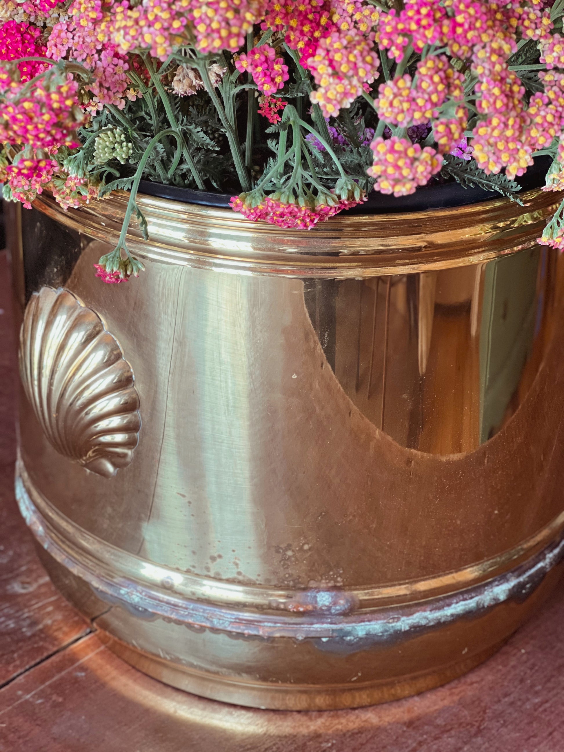 Large vintage English cachepot with shell handles filled with pink flowers.