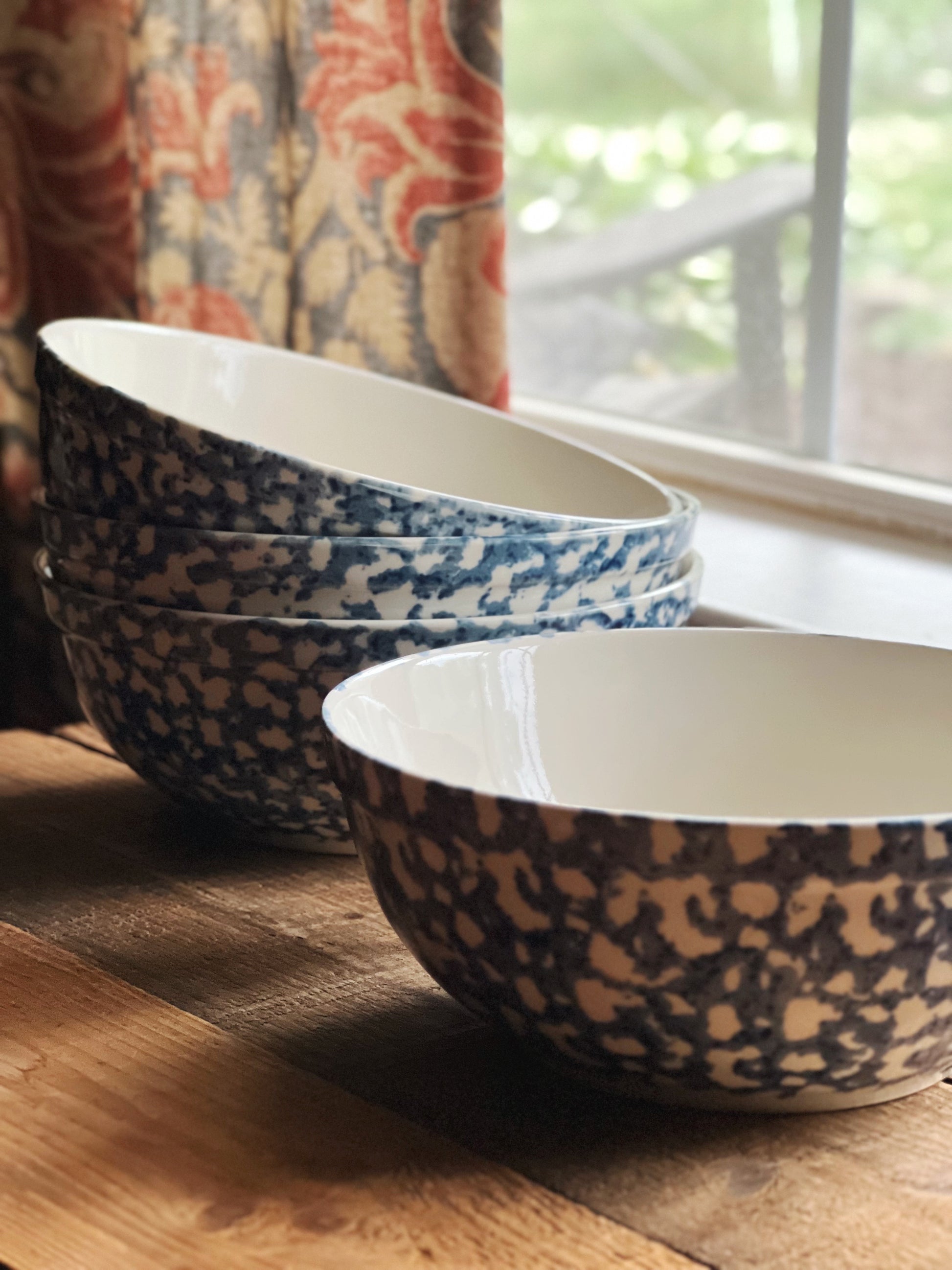 Gibson stoneware bowls on a wooden surface with a window in the background