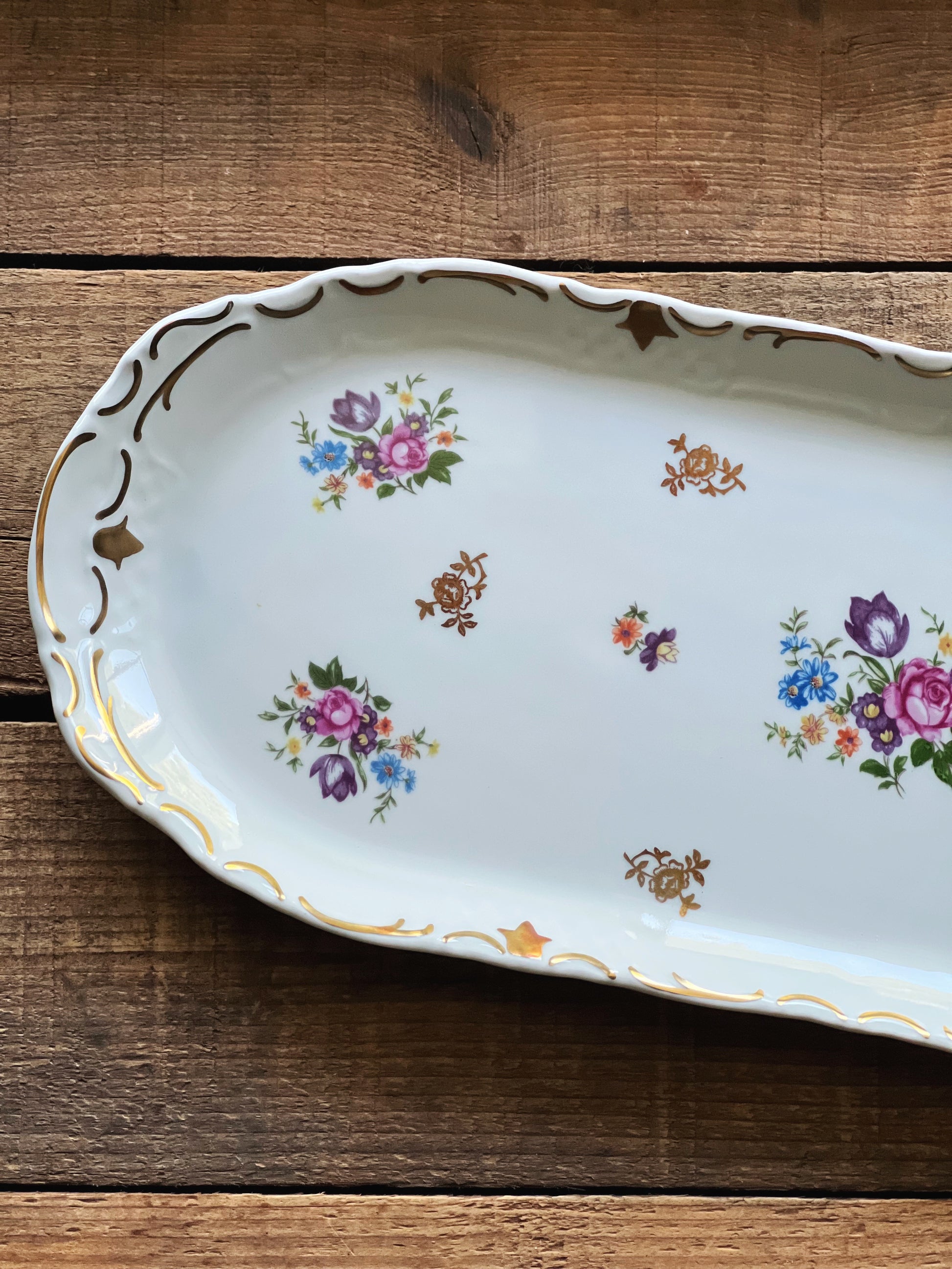Decorative porcelain tray by Reichenbach Germany with floral patterns on a wooden surface