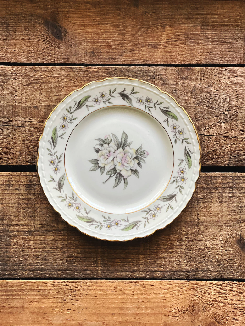 Royal Jackson Fleur De Blanc bread plate with floral design on a wooden surface