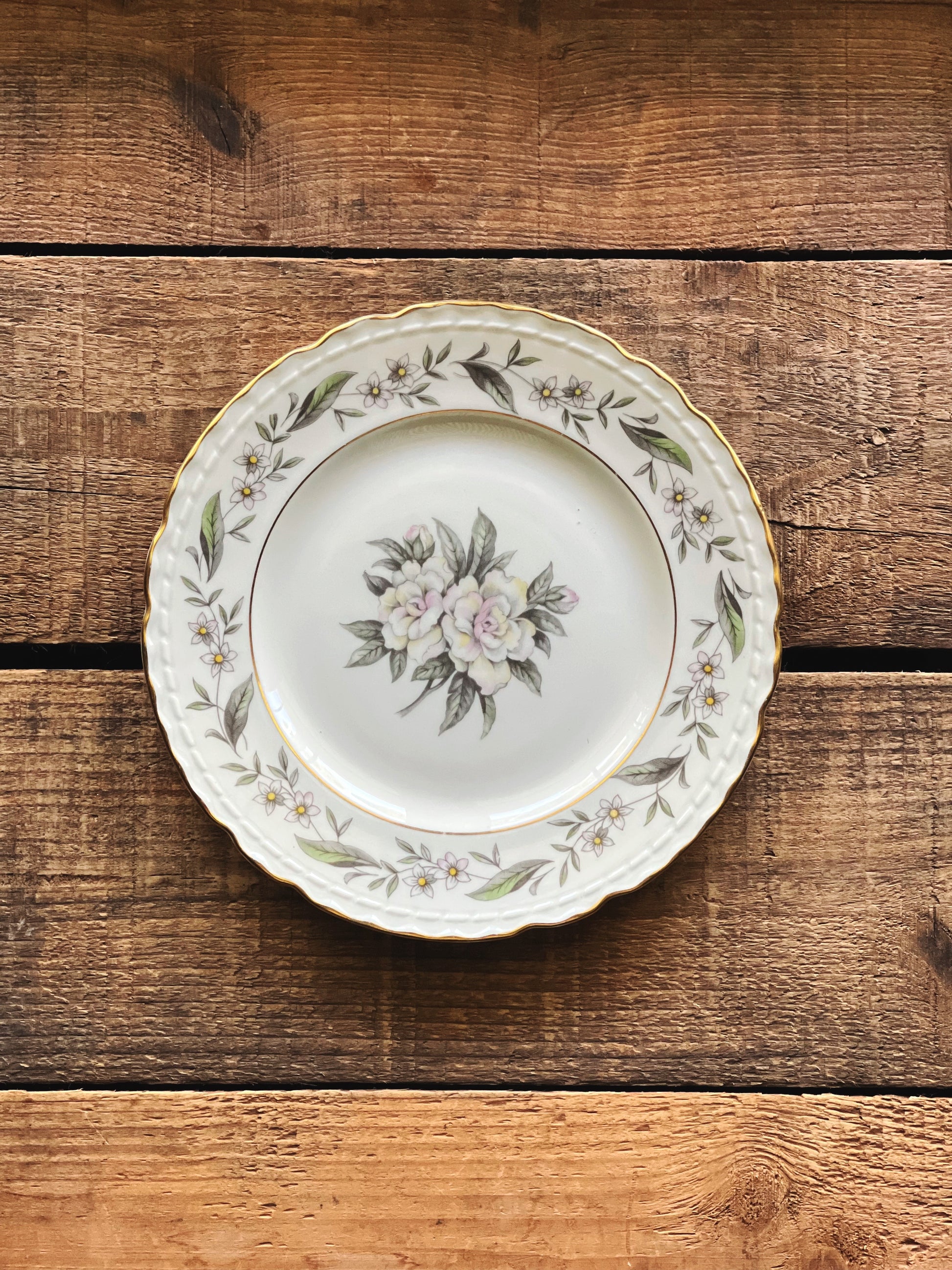 Royal Jackson Fleur De Blanc bread plate with floral design on a wooden surface