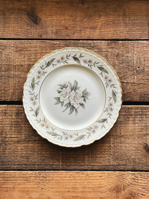 Royal Jackson Fleur De Blanc bread plate with floral design on a wooden surface