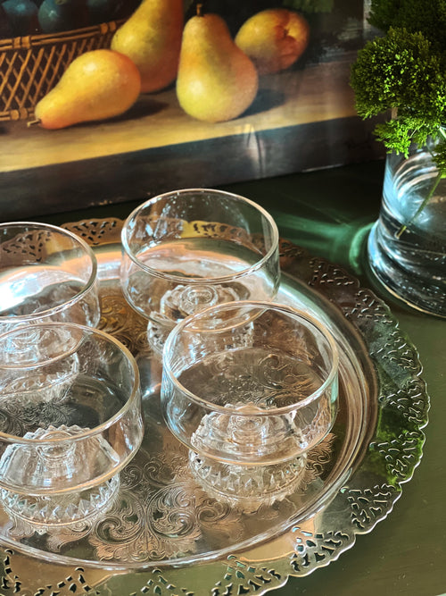 Overhead view of a set of vintage coupe glasses displayed on a silver tray 