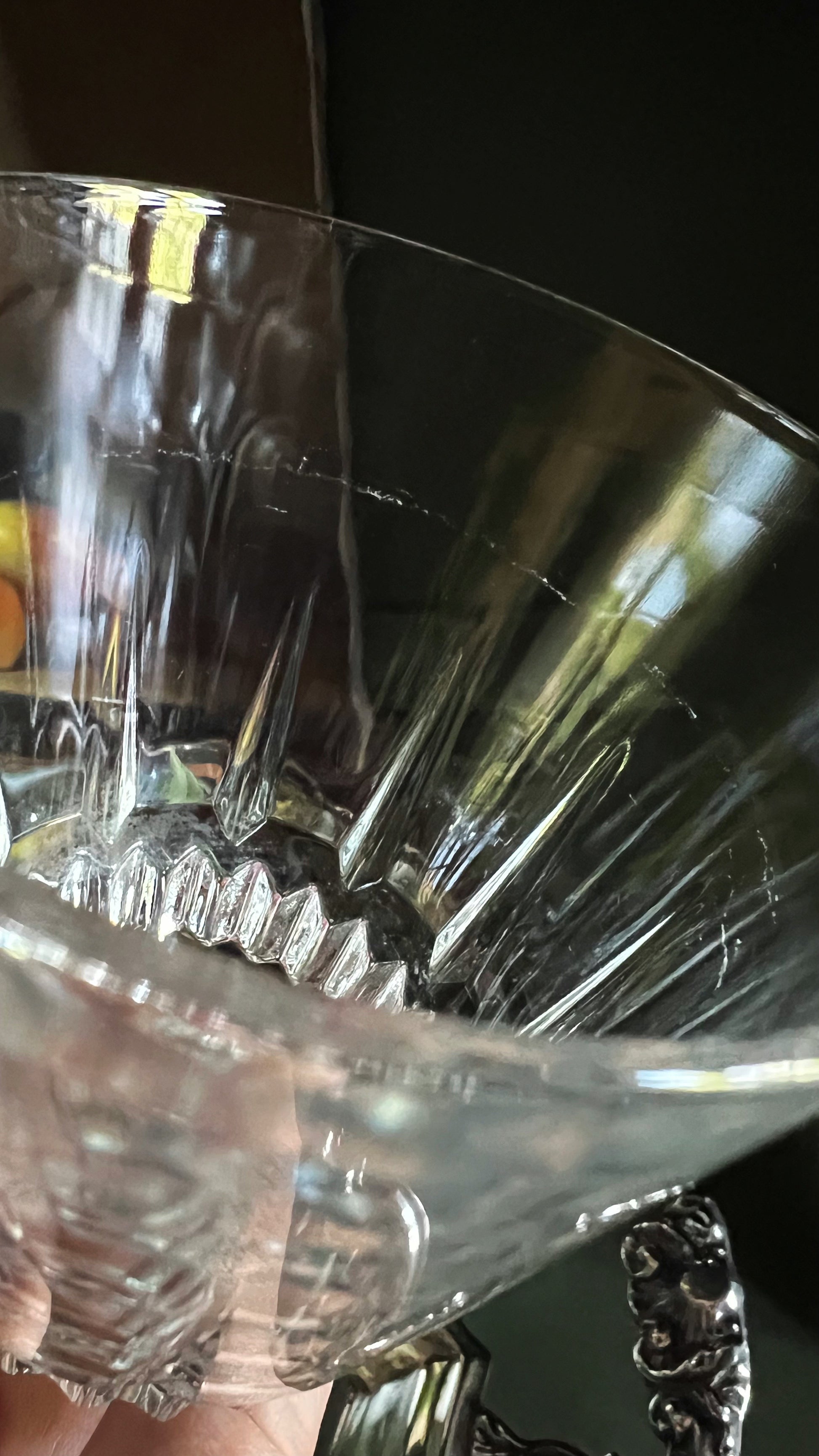 Close-up of a crystal glass with a scratch on a dark background