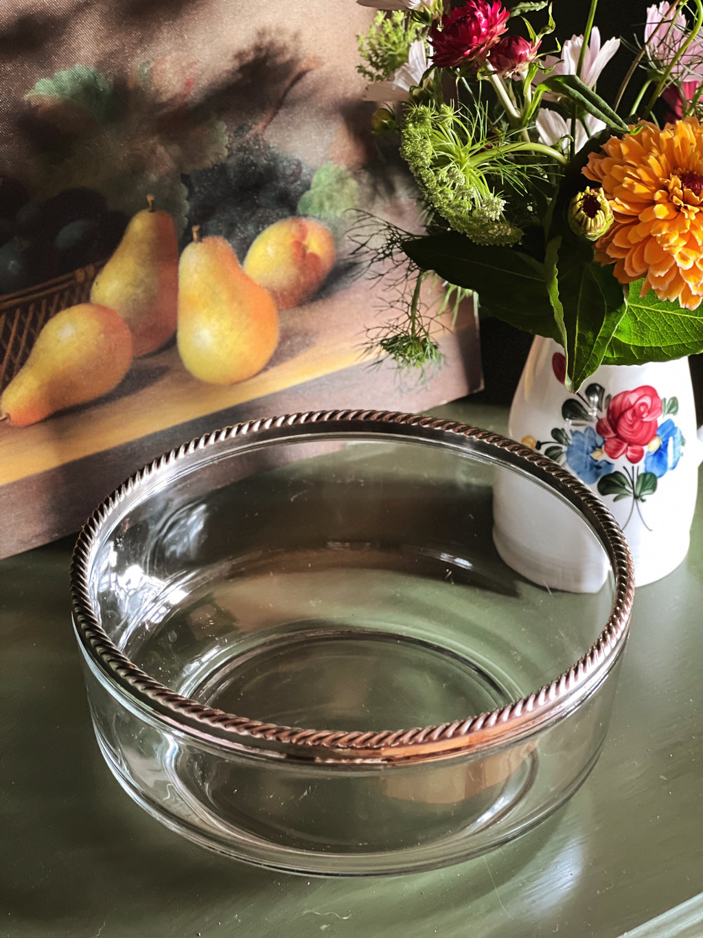 overhead view of a vintage glass serving bowl with an elegant silver rope rim.