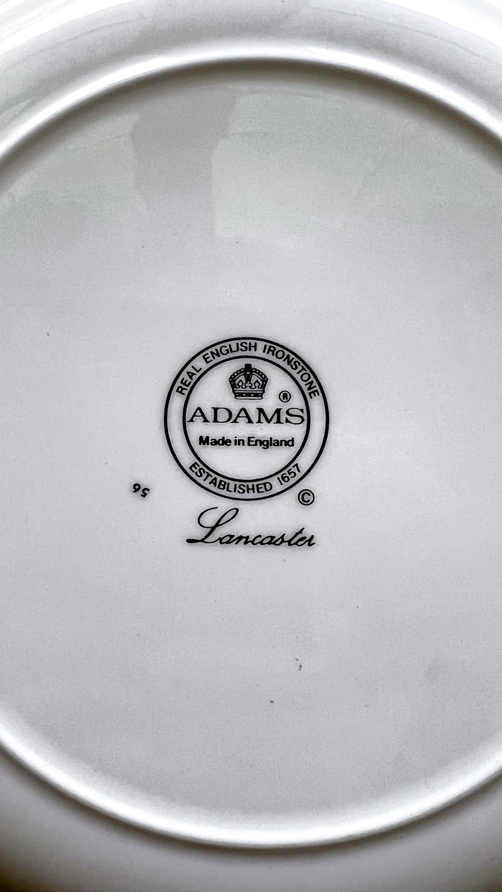 Close-up of a plate with 'Adams' branding on a white background