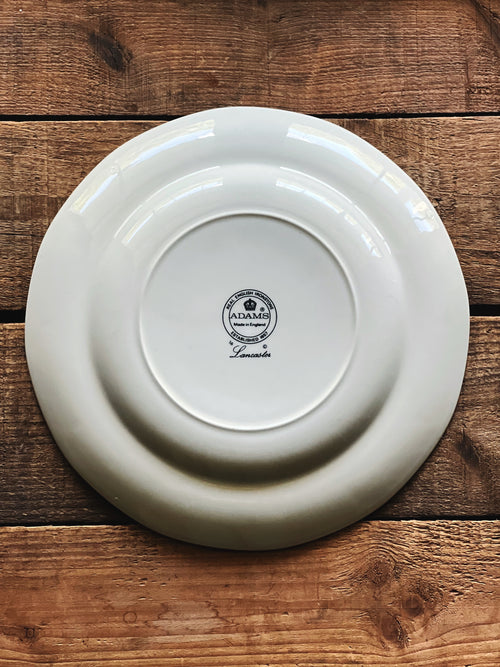 Underside of a vintage Adams Lancaster 9-inch hand-painted English luncheon plate on a rustic wooden tabletop.