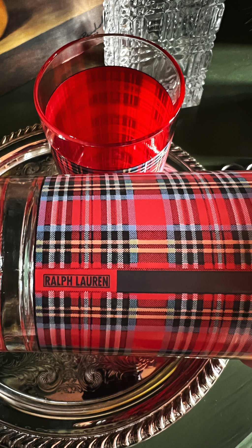 Red plaid highball glasses with 'Ralph Lauren' branding on a reflective surface.