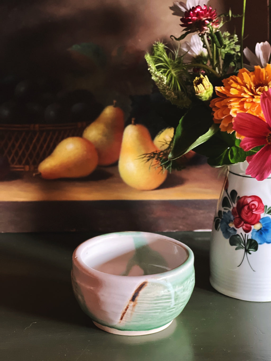 Handmade signed JMC pottery bowl with a soft sage green glaze and earthy accents