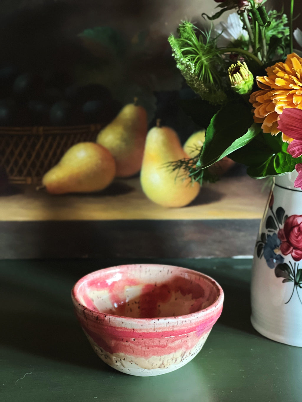 Handmade Pink Drip Glaze Pottery Bowl with a drip glaze next to a flower arrangement