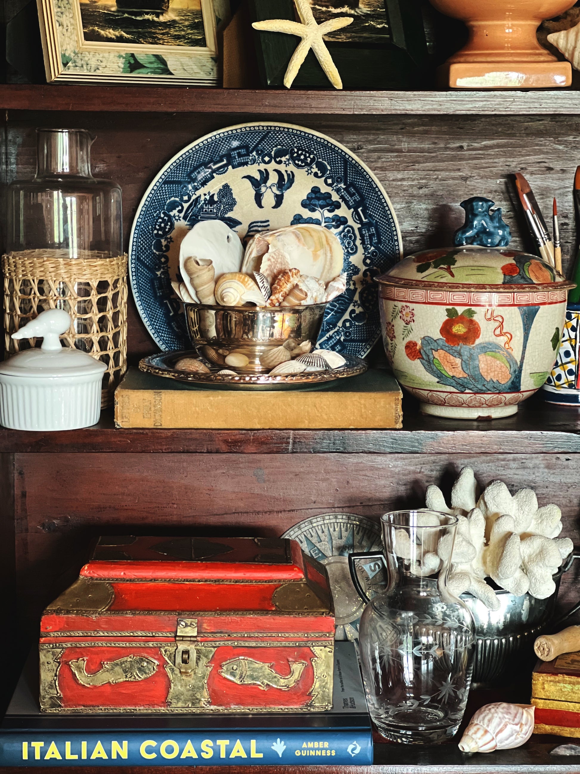 Vintage wooden keepsake box with decorative brass inlay displayed on a styled bookshelf