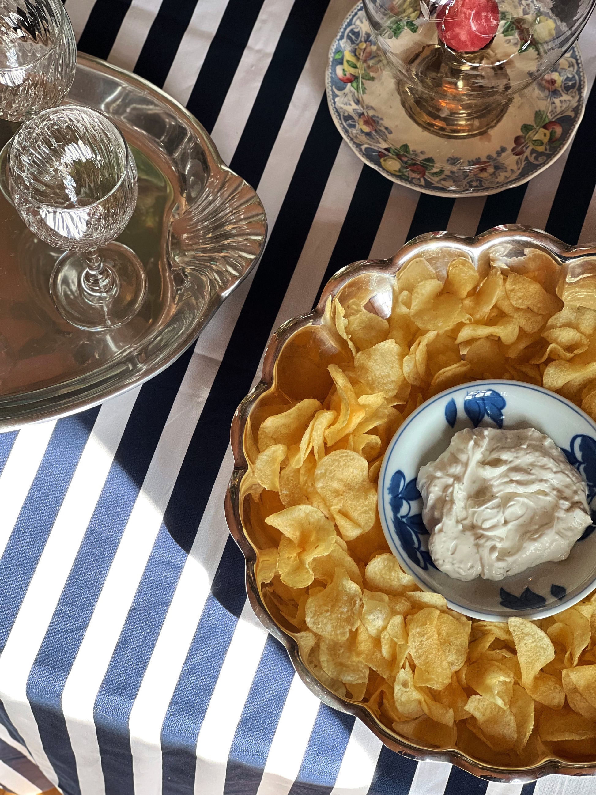 Vintage Reed & Barton Holiday silverplate chip and dip serving bowl with scalloped edge styled with potato chips and onion dip.