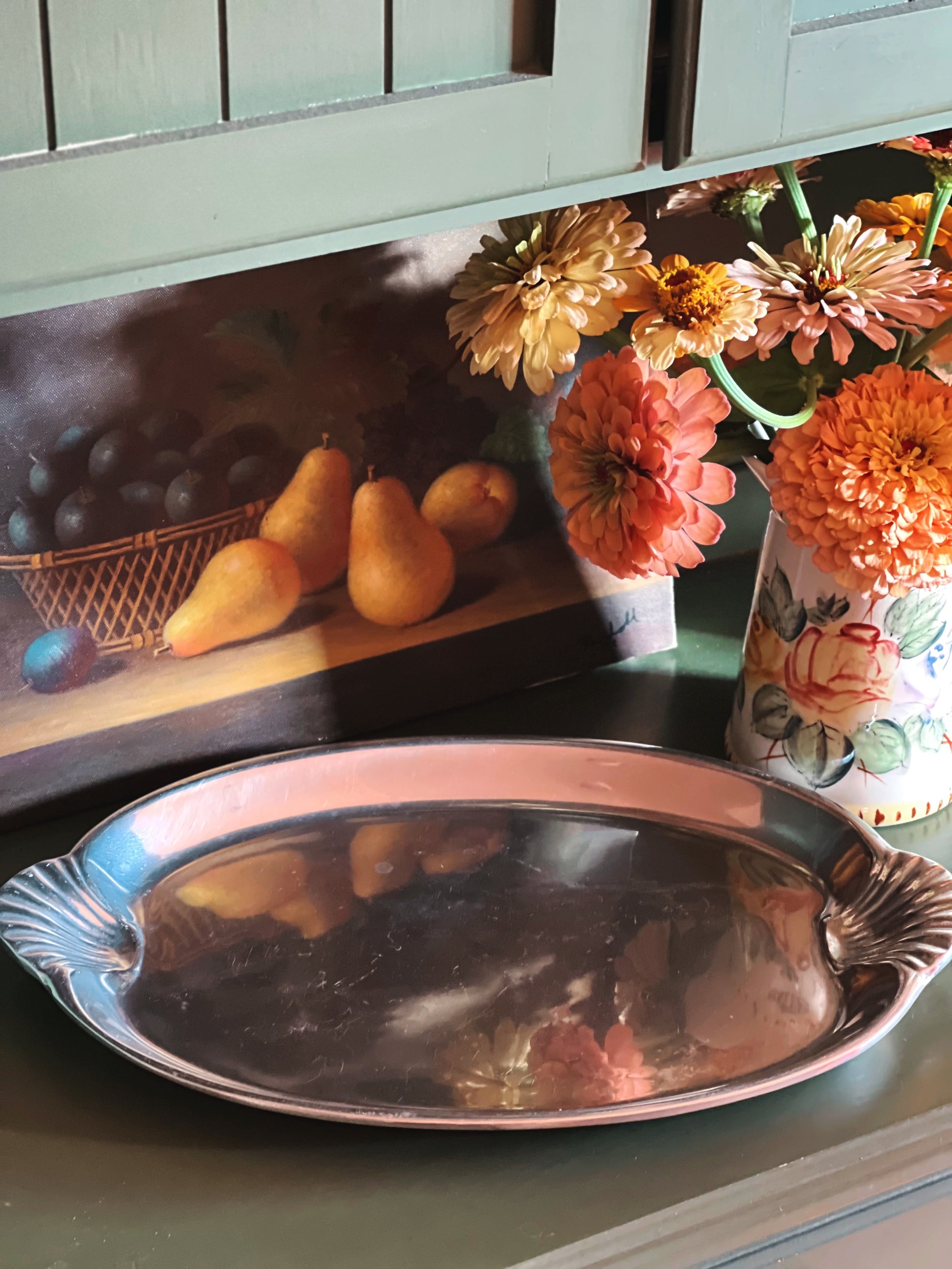 Wilton Armetale silver tray on a kitchen counter with pears, flowers, and a vase.