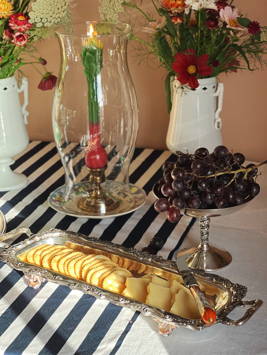 Vintage Ornate Footed Silver Serving Tray on a table with candlelight, grapes and flowers