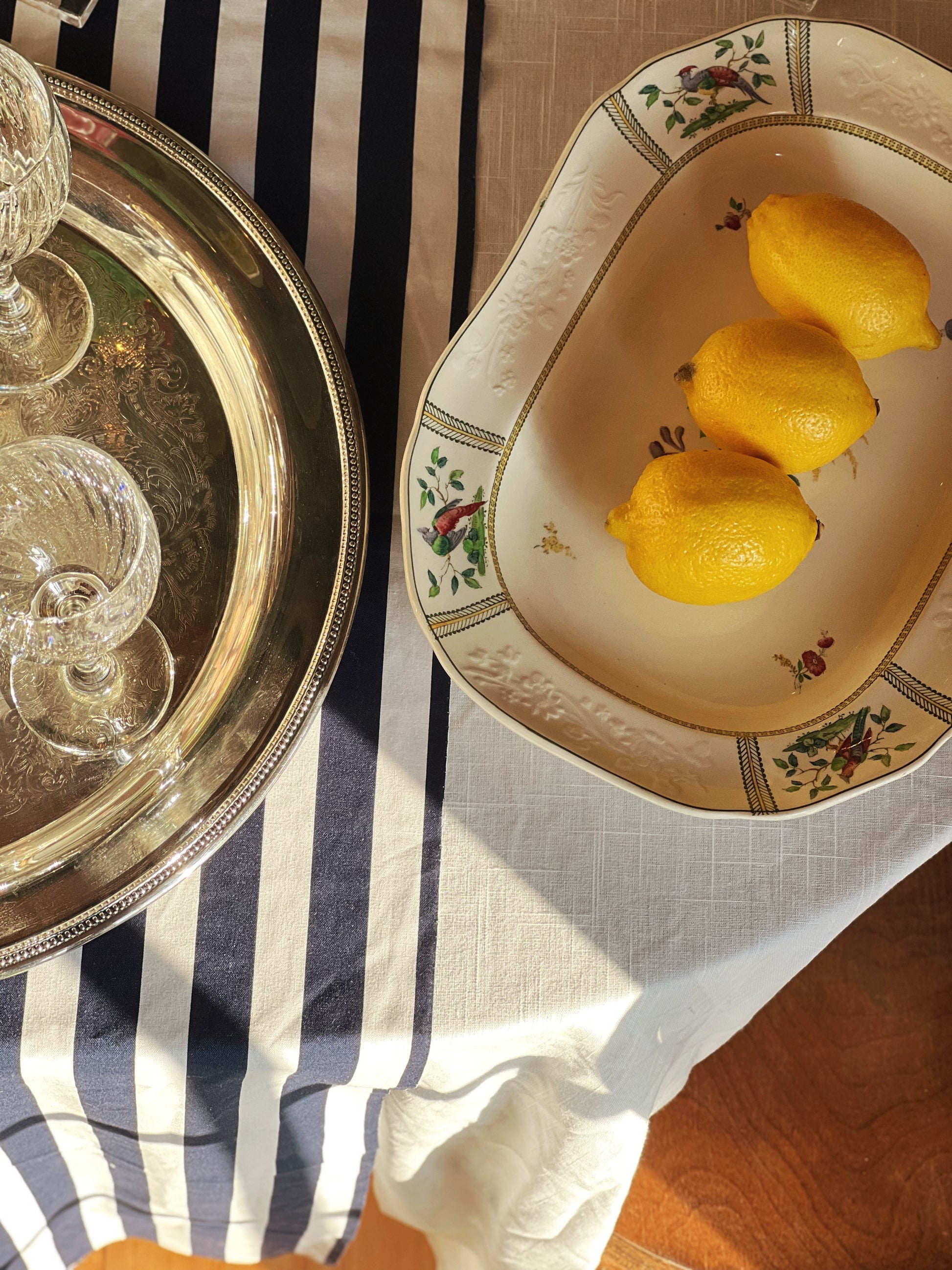 Spode serving platter in the June pattern on a table with lemons and wine glasses