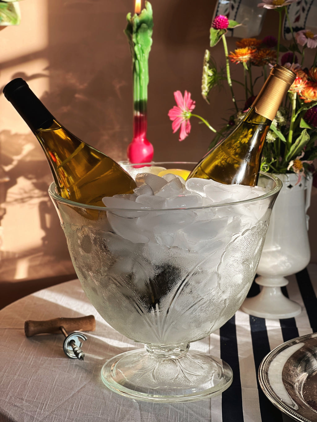 Vintage Glass Cabbage Leaf Pedestal Bowl filled with ice and wine bottles on a table set for entertaining