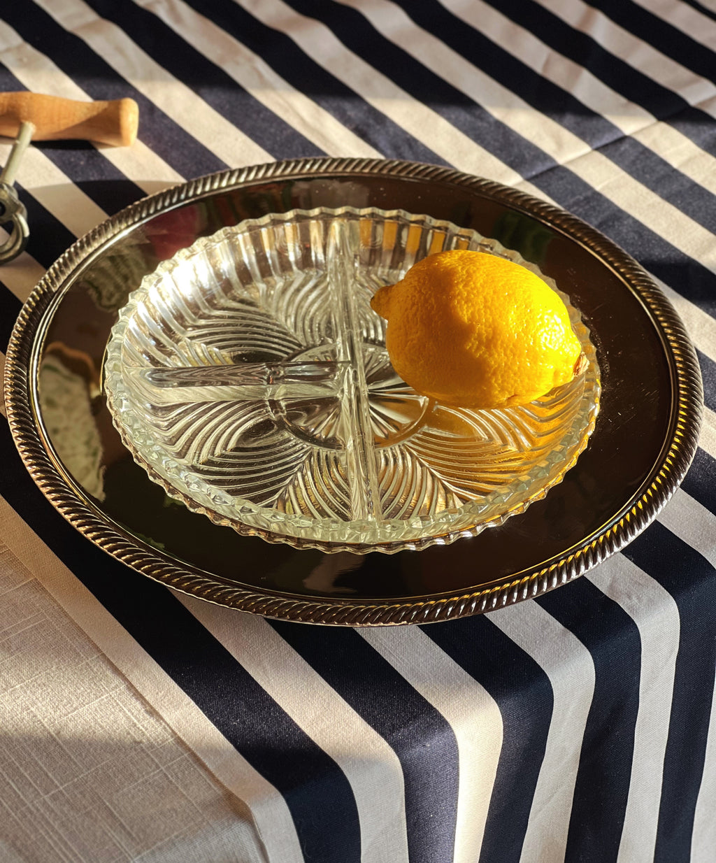 silver and cut glass relish tray on a table with a navy and white striped tablecloth