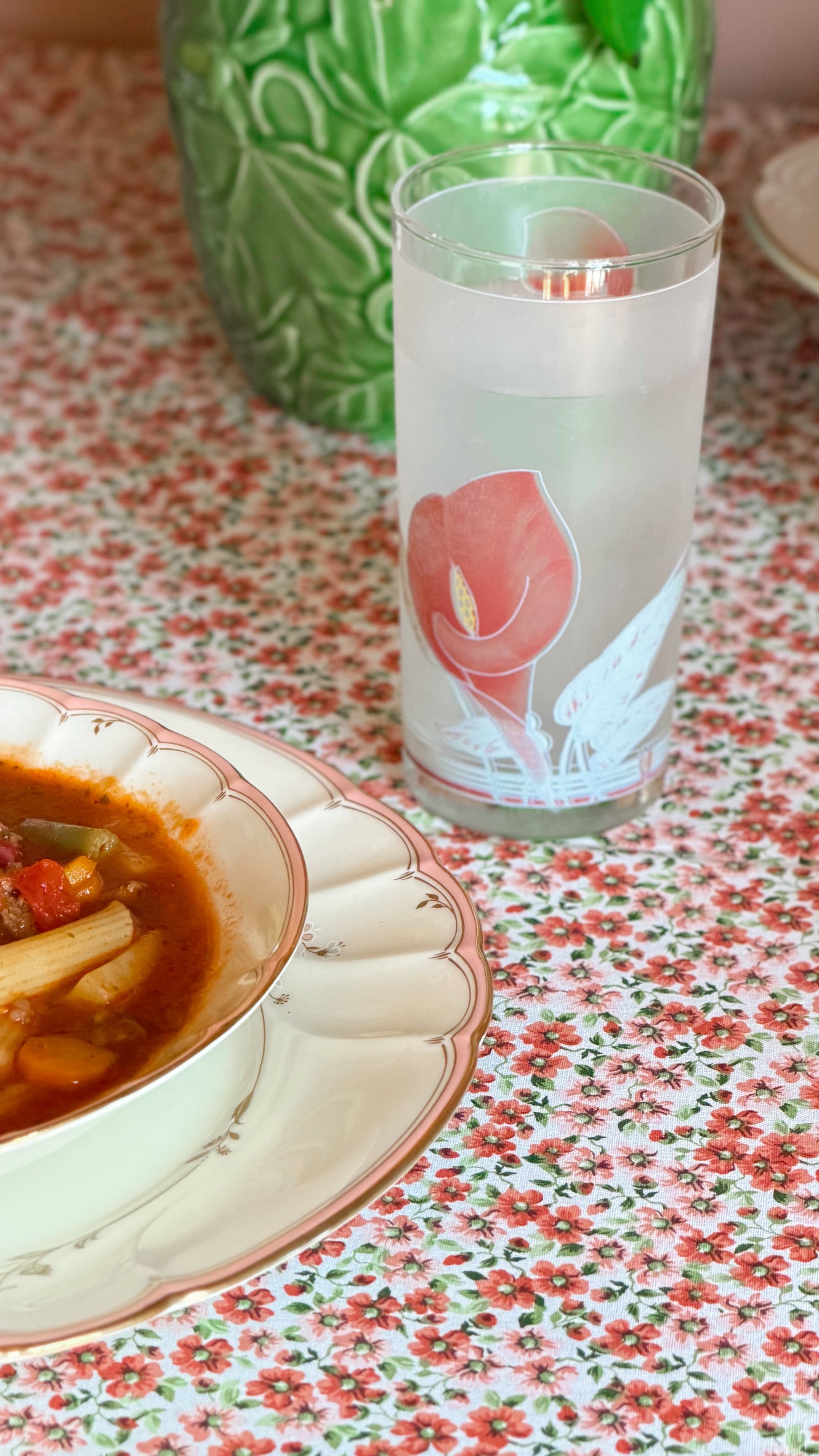 Vintage Noritake Eternal Blush frosted highball glass with pink calla lily floral design styled beside a bowl of soup on a gathered farmhouse table.