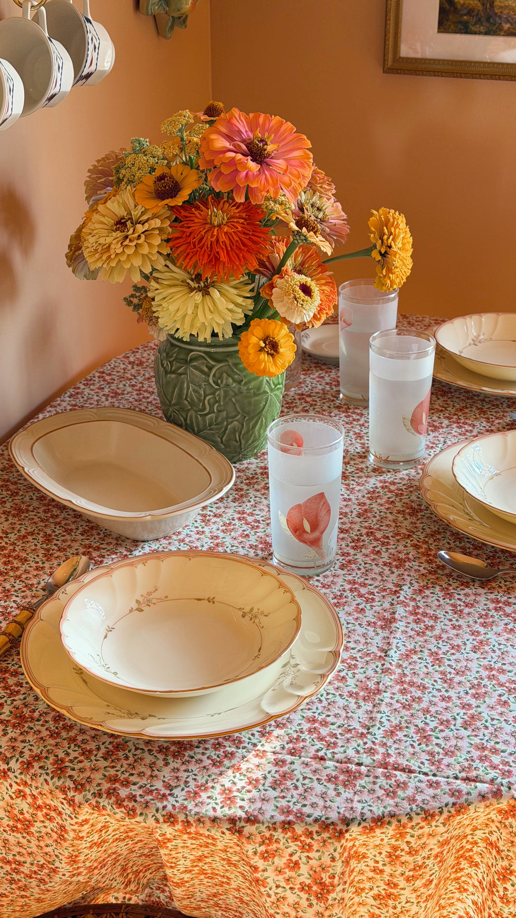 Vintage Noritake Eternal Blush highball glasses with pink floral design displayed on a cozy cottage-style dining table.