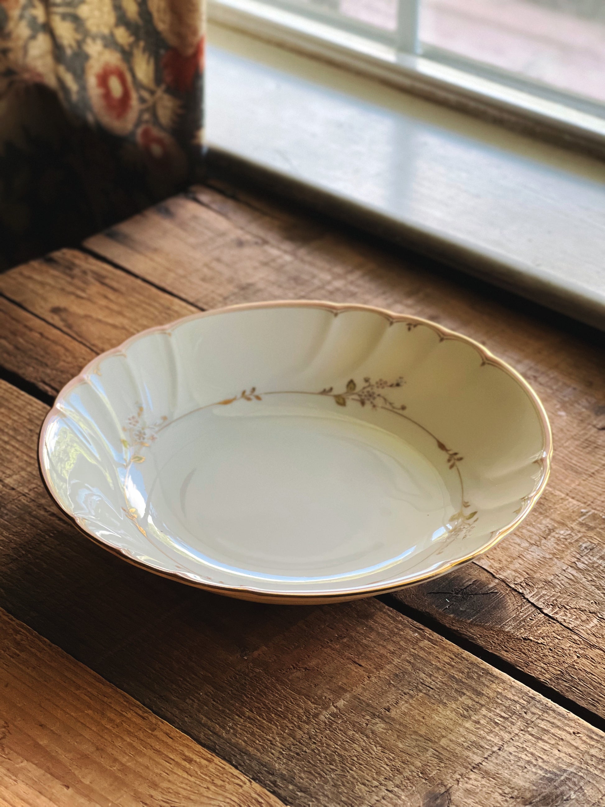 Overhead view of a Vintage Mikasa Monticello coupe soup bowl made in Japan with a delicate pink floral border and gold trim. 