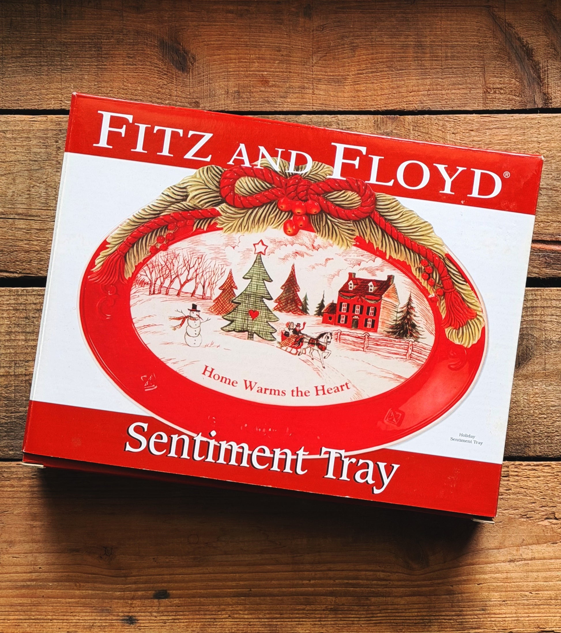 Fitz and Floyd Sentiment Tray gift box with a red and white holiday design, placed on a rustic wooden surface.
