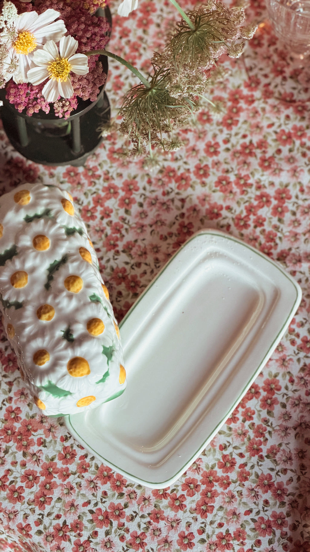 Lefton Daisytime Ceramic Butter Dish, set on a pink and white floral tablecloth.