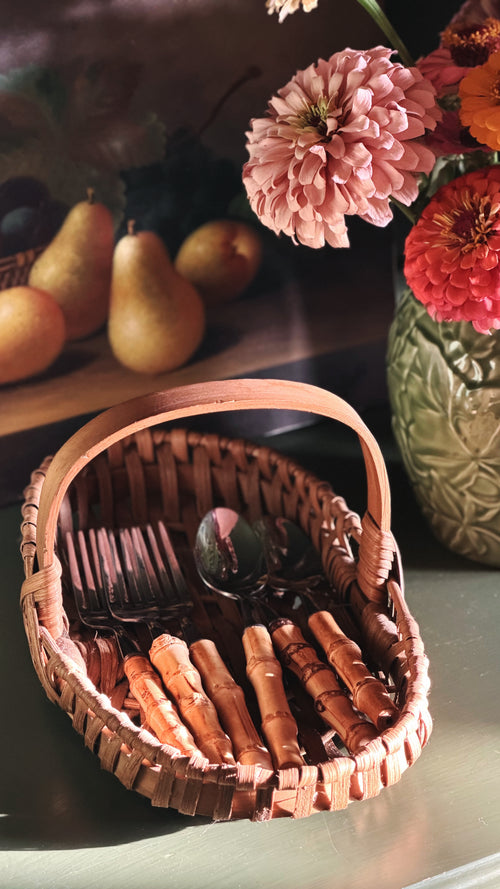 Vintage Woven Single-Handle Tabletop Basket filled with bamboo cutlery