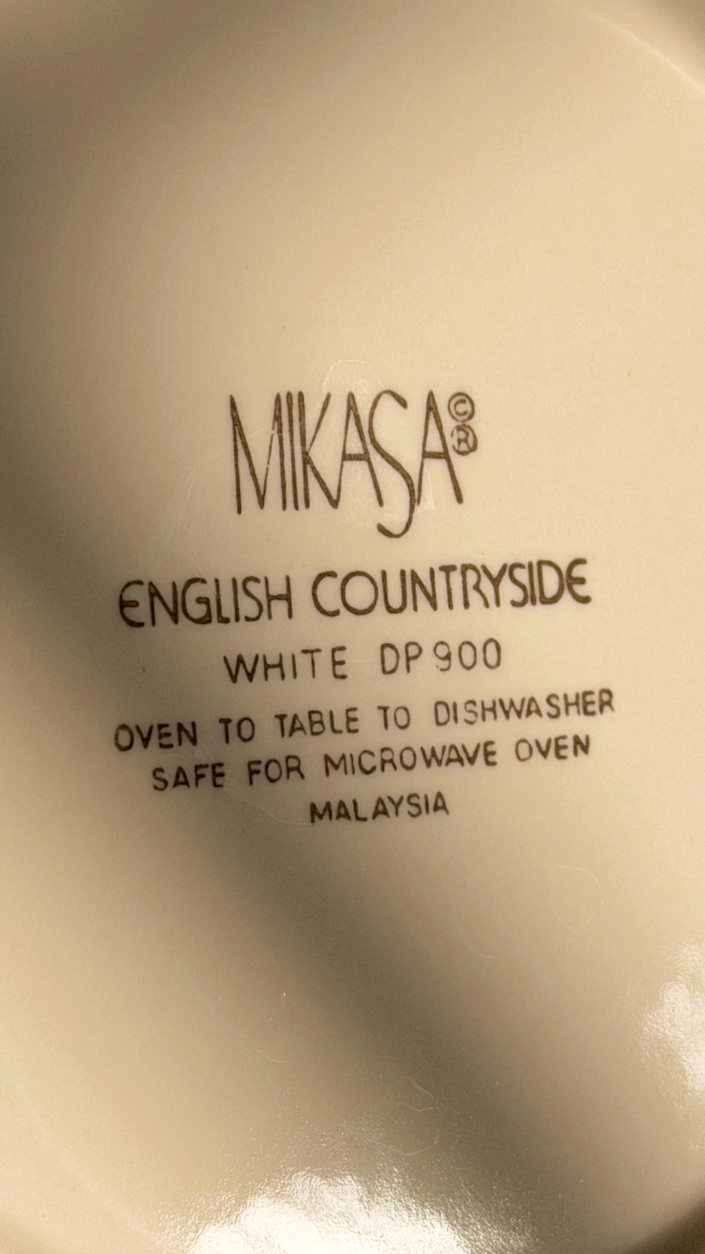 Close-up of the inside of a Mikasa ceramic dish, showing the printed text 'ENGLISH COUNTRYSIDE WHITE DP900' and other product details.