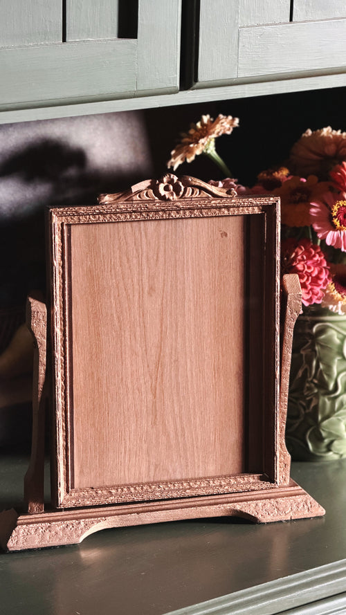 Vintage Gold-Toned Easel Picture Frame on a green shelf