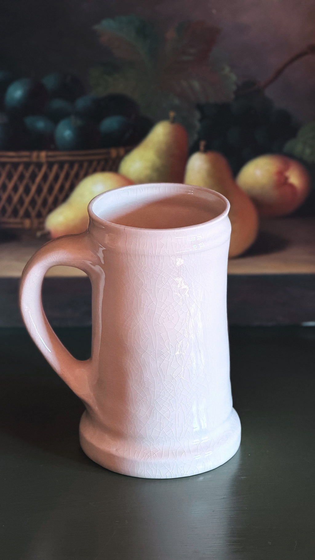A Vintage English Pheasant & Partridge Mug with a textured glaze, set against a dark background with a painted still life of pears and grapes.