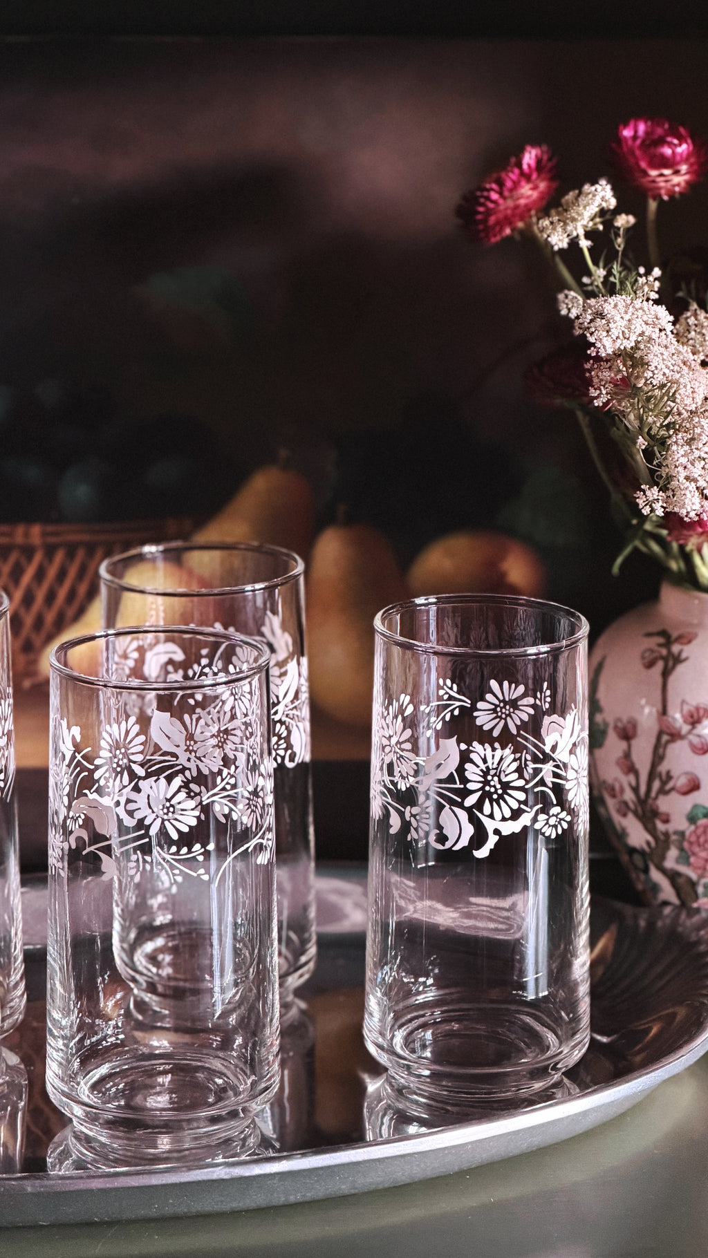 Set of 4 Vintage White Floral Highball Glasses in front of a still life painting 