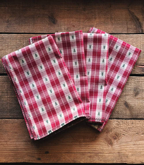 Set of 4 Vintage Red Plaid Christmas Tree Cloth Napkins arranged on a rustic wooden background.