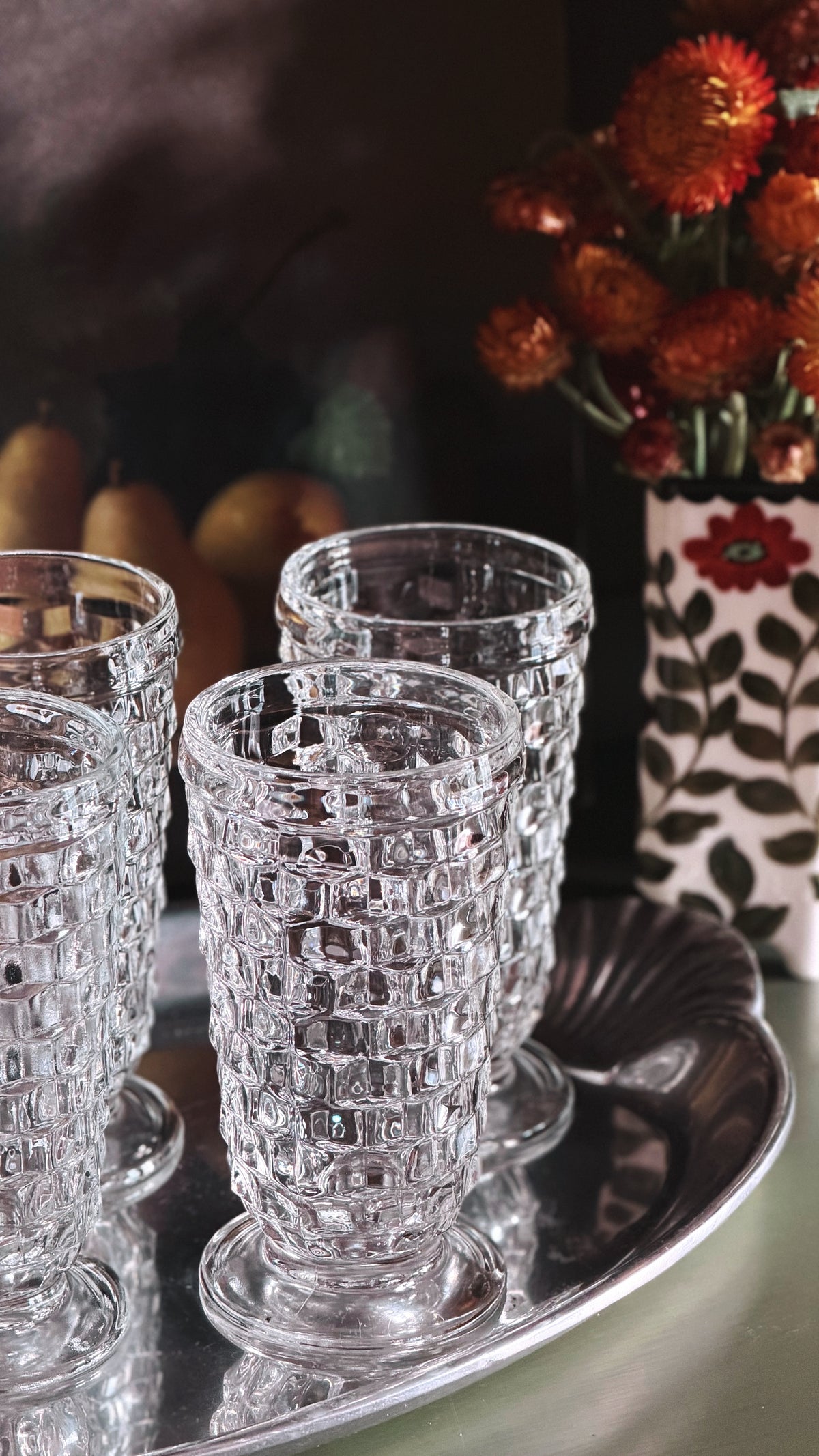 Set of 4 Vintage Colony Whitehall Clear Iced Tea Glasses next to a flower arrangement on a green table.